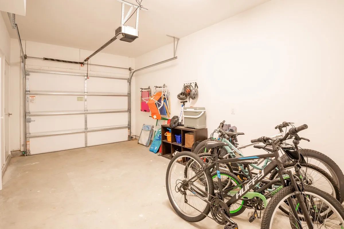 An interior shot of a garage or storage space featuring bicycles ready for use, alongside smart storage solutions and a garage door leading out. The focus is on the practical side of adventures, highlighting the ease of grabbing a bike for a day of exploration around the island.